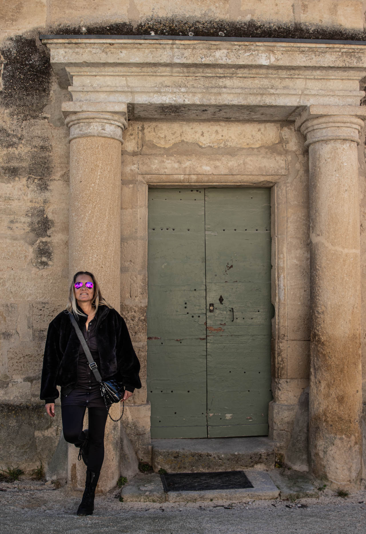 Frau mit schwarzer Stronger Leggings und Jacke vor einer alten Tür