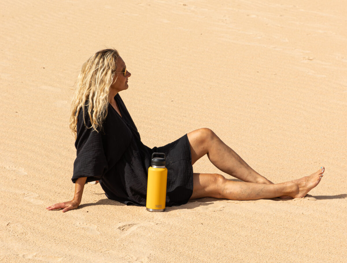 Frau im Sand mit gelber Yeti Tumbler Bottle