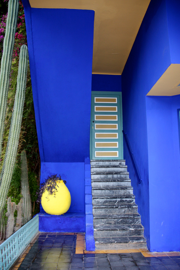 Blaues Haus mit Treppe und gelbem Blumenkübel im Jardin Majorelle in Marrakesch 2016