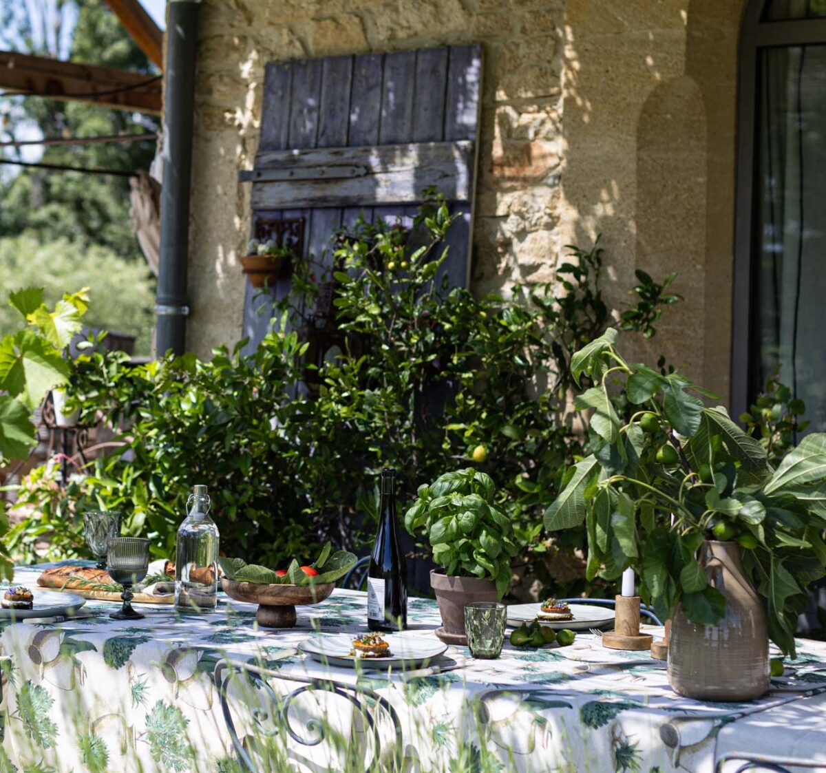 Frühlingshafte Tischdeko Dekoria gedeckter Tisch Basilikum Vase Feigenblätter Holzschale Sonnenschein