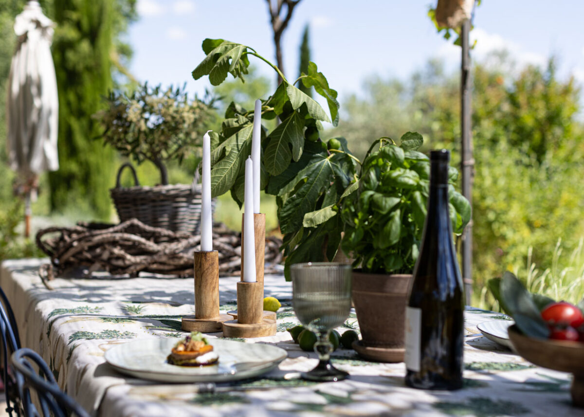 Frühlingshafte Tischdeko Dekoria Teller Glas Holzkerzenständer Basilikum Weinflasche